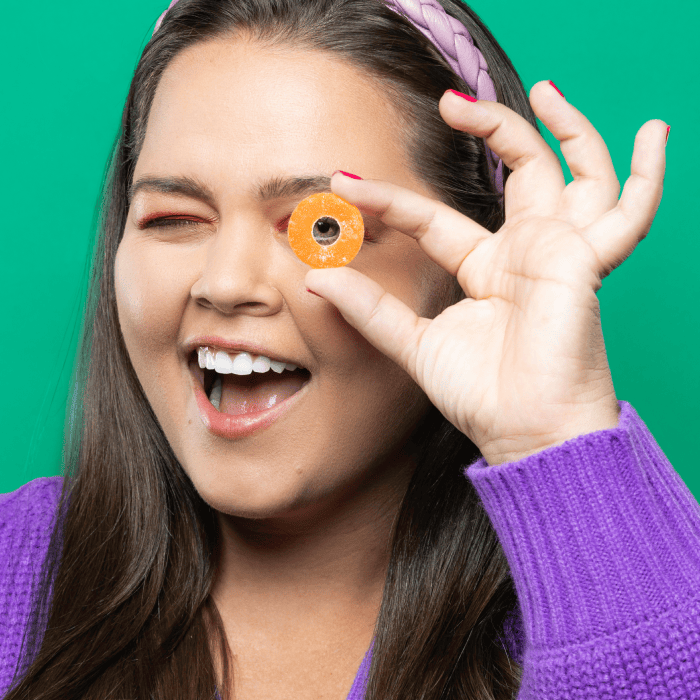Woman holding Peach Ring to her eye