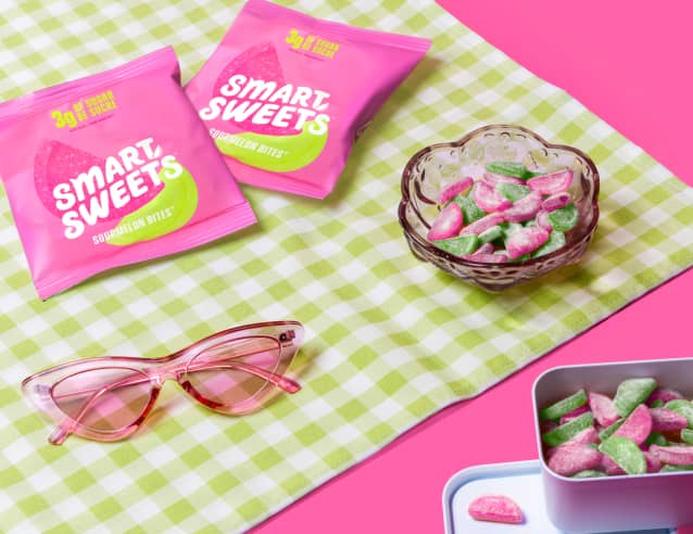 Sourmelon Bites pouches and bowl of Sourmelon Bites on picnic blanket