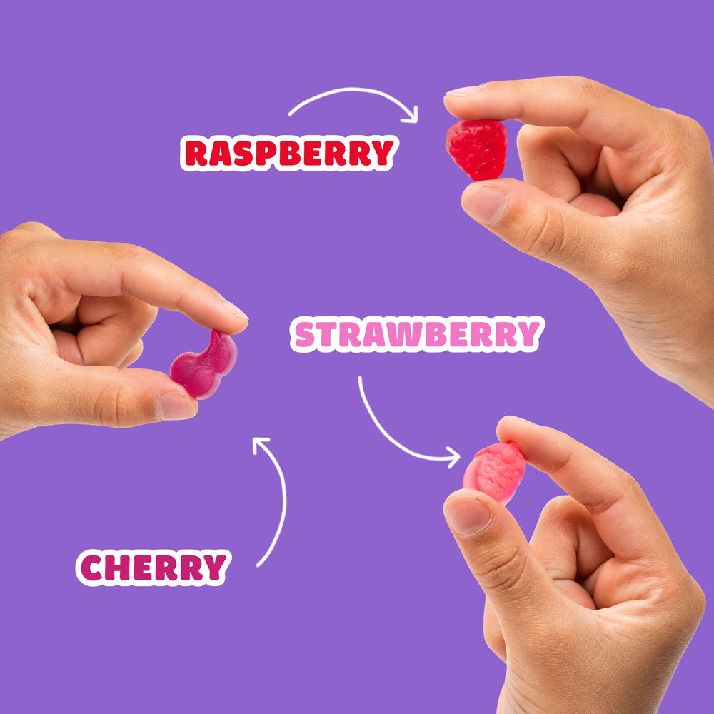 Hands holding fruit snacks labeled RASPBERRY, TRAWBERRY, CHERRY.