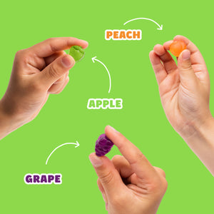 Hands holding fruit snacks labeled PEACH, APPLE, and GRAPE.